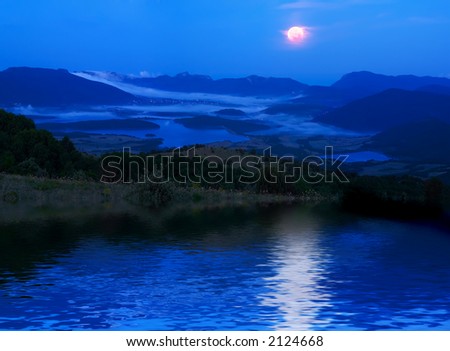 A moonlight night in mountains with reflections on water