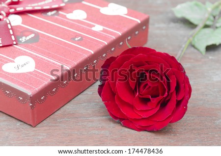 Red gift boxes and rose on wooden background