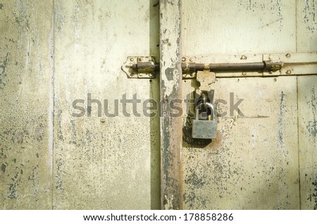 Vintage key unlocking an old cracked antique or vintage door