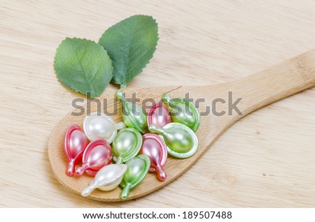 Natural vitamins for good health in a wooden spoon on a wooden background.