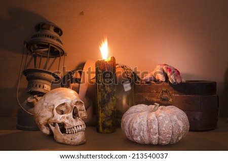 Halloween image with a burning candle on an ancient skull