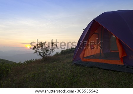 recreation area and camp with tent, sunset time with rising sun near high mountain lake