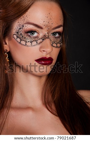 wonderful brunette woman with mask on face, creative makeup mask