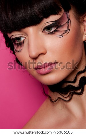 pretty woman with creative makeup and hairstyle on pink background