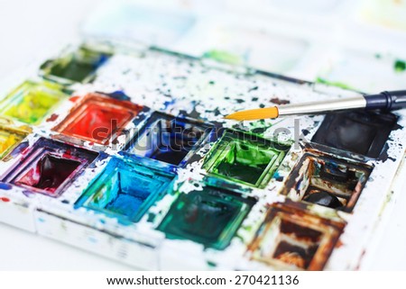 Dirty water color paint box set with paint brush.