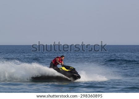 CAMYUVA, KEMER, TURKEY - JULY 16, 2015: Unidentified Turkish man glides over the waves of the Mediterranean Sea on Jet Ski. Extreme water sports are increasingly popular on the beaches of Turkey
