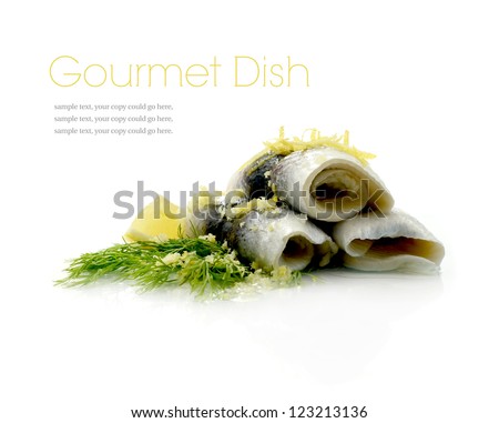 Studio macro of delicious herring (roll mop) dish on reflective surface against a white background. Copy space.