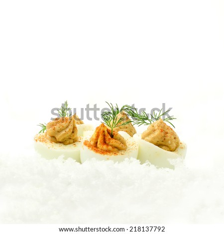 Fresh deviled eggs, also known as curried eggs, with dill garnish in snow. The perfect image for your restaurant menu cover design. Copy space.