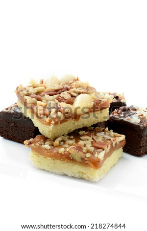 Freshly baked chocolate brownies with brown and white chocolate curls against a white background. Copy space.