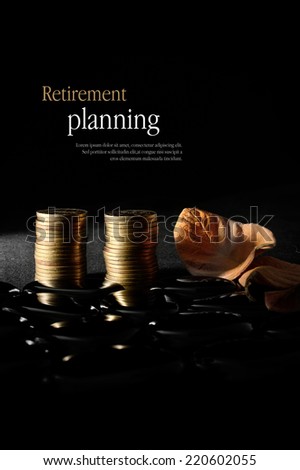 Concept image for retirement planning. Creatively lit golden coins with autumnal leaves representing older clients and their investments against a dark background. Copy space.