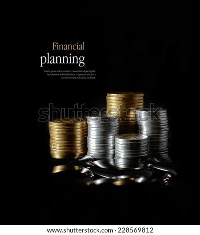 Concept image for financial planning. Creatively lit, stacked generic gold and silver coins representing client investment or savings. Copy space.