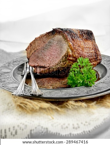A fresh oven roasted joint of silverside beef in a light, bright setting accentuating the quality of the food. The perfect image for a bistro or restaurant Sunday lunch design. Generous copy space.