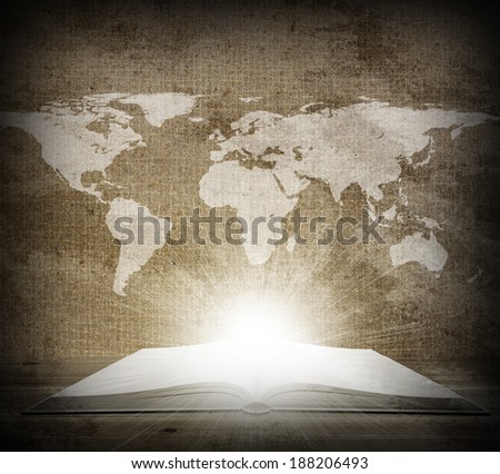Open book lying on the floor. Over an open book is a map of the earth