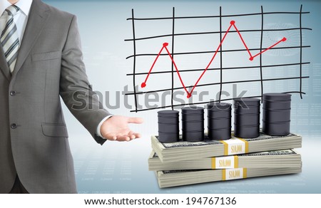 Businessman points hand on barrels oil and money. Schedule of price increases in background
