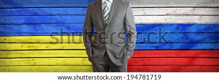 Businessman in a suit. Ukrainian and Russian flags as background. Concept of business