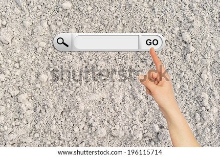 Human hand indicates the search bar in browser. Cultivated brown soil surface on background