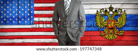 Businessman in a suit. USA and Russian flags as background. Concept of business