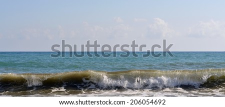 Sea wave rolled ashore. Blue sky in the background
