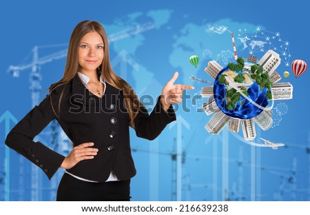 Beautiful businesswoman in suit finger points to Earth with buildings. Map of world, construction site and arrows in background. Elements of this image are furnished by NASA