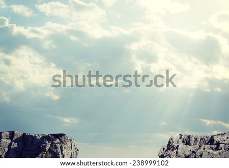 Gap in rocky pathway or chasm between two rocks. Sky and clouds as backdrop