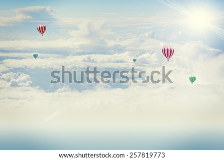 Shot from an airplane. Background of clouds and sun with hot air balloon