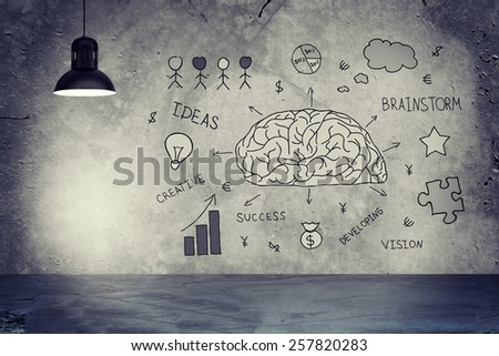 Concrete gray wall with sketches of brain, diagram, bulb, money, development of ideas and star. Left standing lampshade with directional light