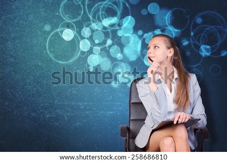 Woman in jacket and blouse sits on chair and looking up. Abstract background