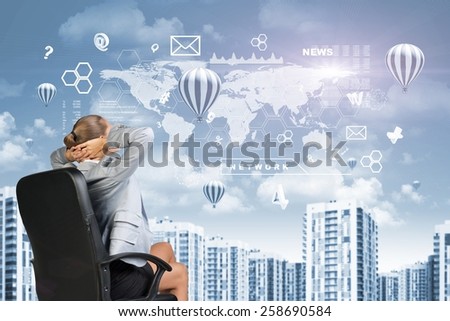 Woman in jacket look at sky. Air balloons with virtual elements in sky. Background of building