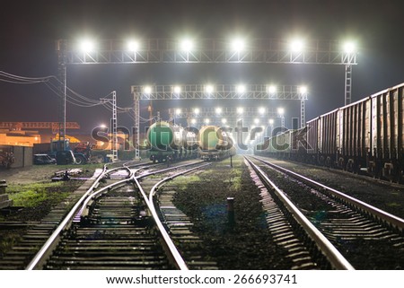 Rail yard with railroad cars and cisterns. Night view