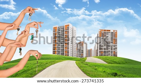 Cityscape under blue sky with keys in several hands