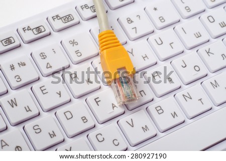 Computer keyboard with yellow cable, close up view