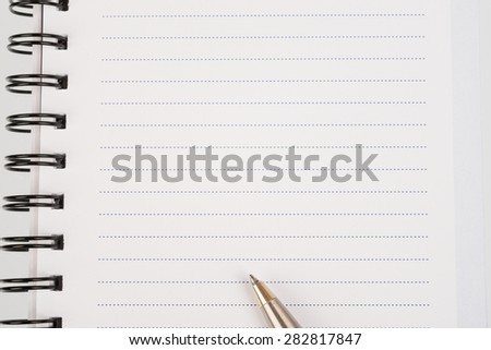 White ring-bound notebook with pen, close-up view