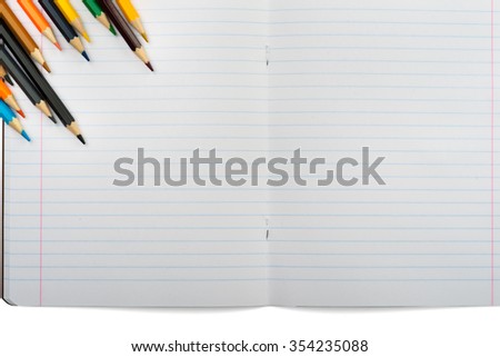 Open notebook with crayons on isolated white background, closeup