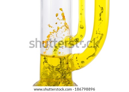 vertical glass reactor pipes with  eruption of boiling yellow liquid  on white separated