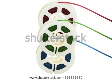 Three film tape reels with RGB colors separated on white