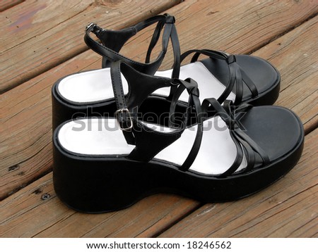 pair of black high heel sandals  on wood deck
