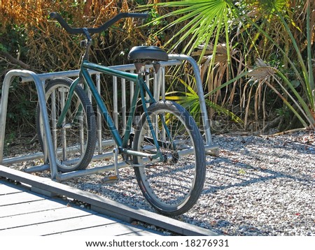 a lone bicycle parked in bike rack