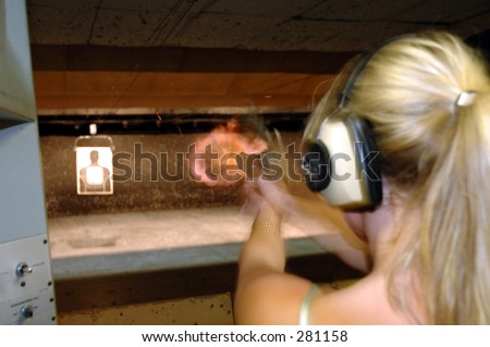 Girl shoots an gun range.