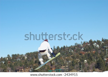 Snowboarder going off of a big jump.