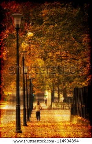 Man running at alley in autumn park. Photo in old image style.