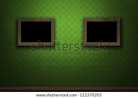 Old wooden frames on green retro grunge wall