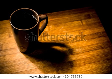 Coffee in mug on edge of wooden table