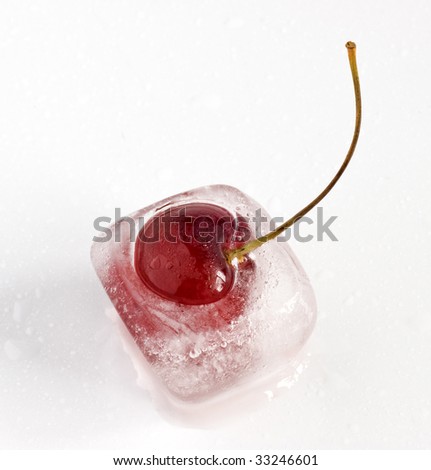 Single cherry frozen inside ice cube, melting.