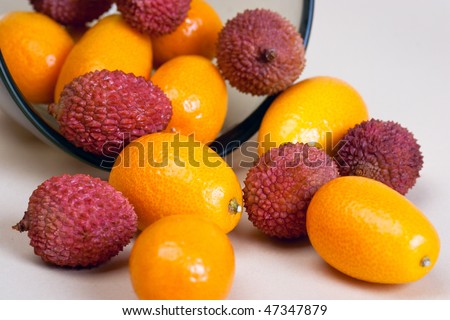 Kumquat and Litchi fruits in the bowl and on the table