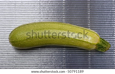 Single green marrow on a ribbed steel background