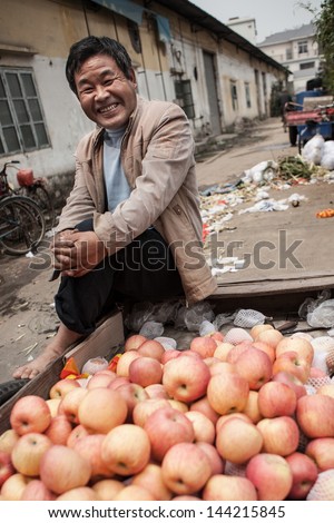 FOSHAN, GUANGDONG/CHINA - MARCH 16: Unidentified street vendor displays fresh apples, Shunde District of Foshan City, Guangdong Province in Southern China on March 16th, 2013.