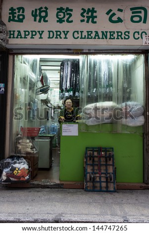 HONG KONG - MARCH 16: Unidentified dry cleaners worker waits for next customer, Kowloon, Hong Kong on March 16th, 2013