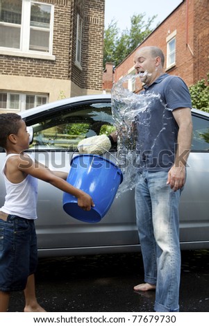 Father and son washing a car horseplay splashing