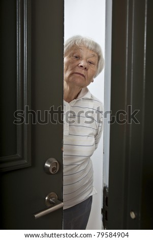 Annoyed senior woman opening front door