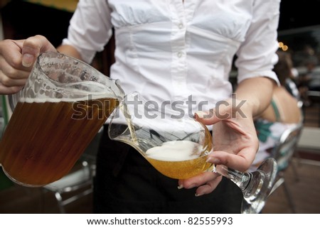 Beer Waitress Bar Maid pouring draught beer from a pitcher